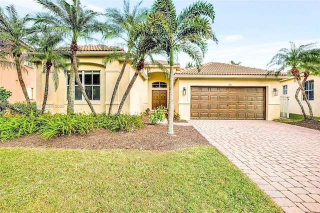 mediterranean / spanish house with a front lawn and a garage