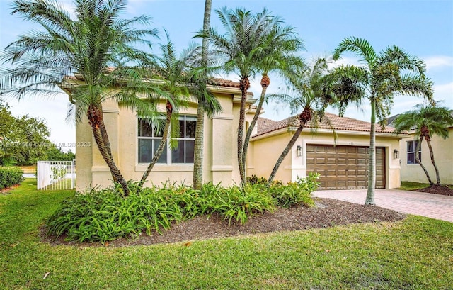 mediterranean / spanish home with a front lawn and a garage