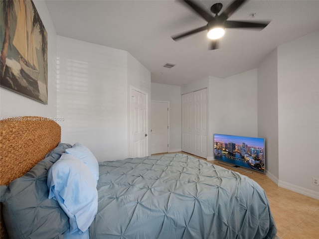 bedroom featuring ceiling fan, a closet, and light tile patterned floors