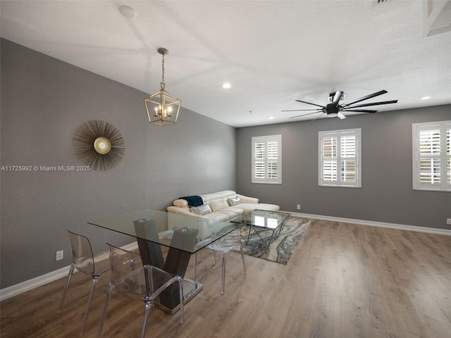 living room featuring ceiling fan with notable chandelier, hardwood / wood-style flooring, and a wealth of natural light