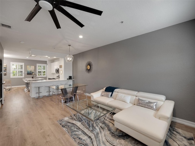 living room featuring ceiling fan and light hardwood / wood-style flooring