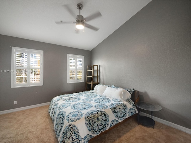 carpeted bedroom with ceiling fan and vaulted ceiling