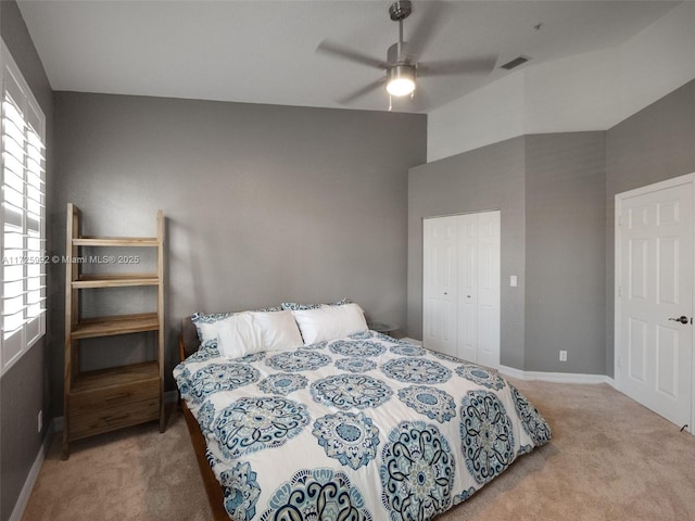 carpeted bedroom with ceiling fan and a closet