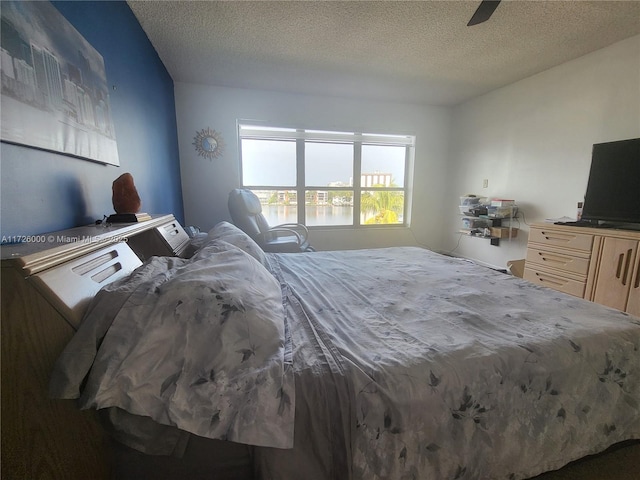 bedroom with ceiling fan and a textured ceiling