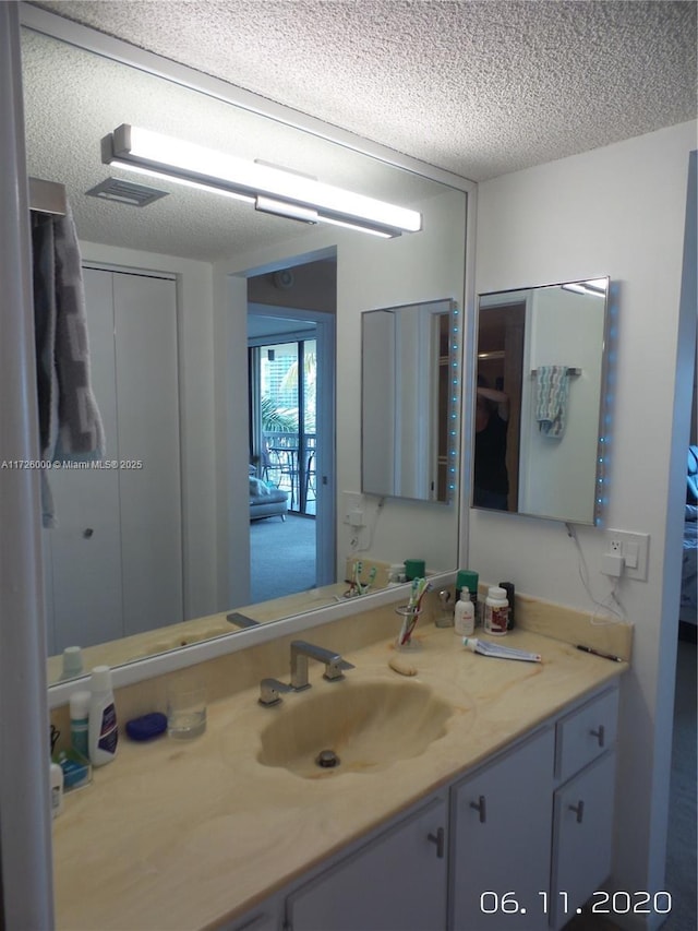 bathroom with a textured ceiling and vanity