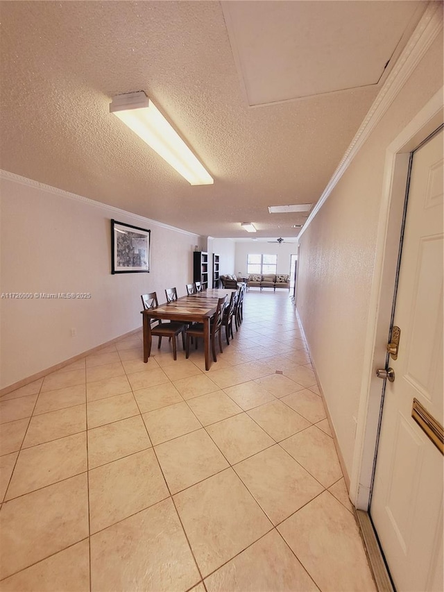 dining room with light tile patterned floors, crown molding, and a textured ceiling