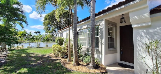 property entrance with a yard and a water view