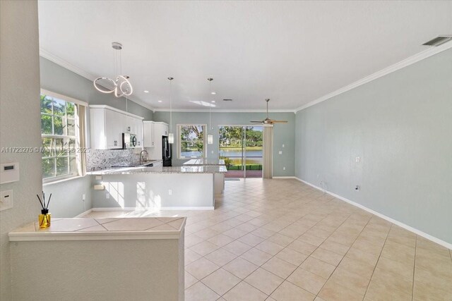 unfurnished living room featuring light tile patterned floors, visible vents, crown molding, and ceiling fan