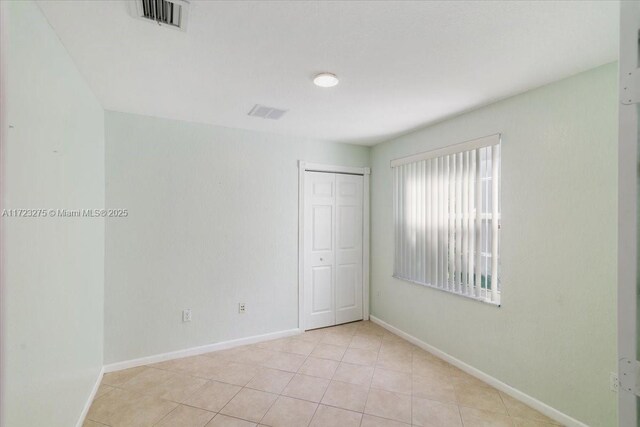 unfurnished room with visible vents, baseboards, and light tile patterned floors