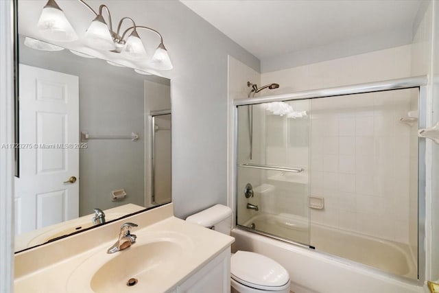 full bath featuring toilet, shower / bath combination with glass door, and vanity