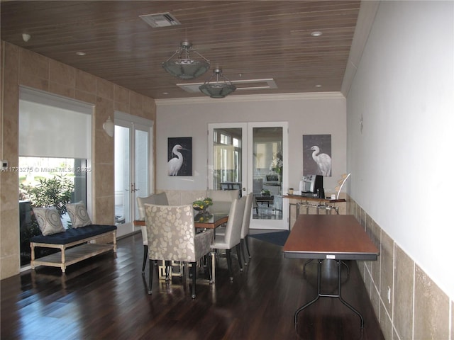 dining area featuring dark wood-type flooring, ornamental molding, wood ceiling, and french doors