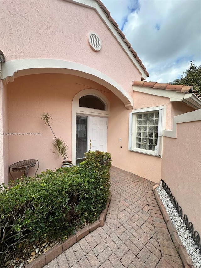 view of exterior entry featuring a patio