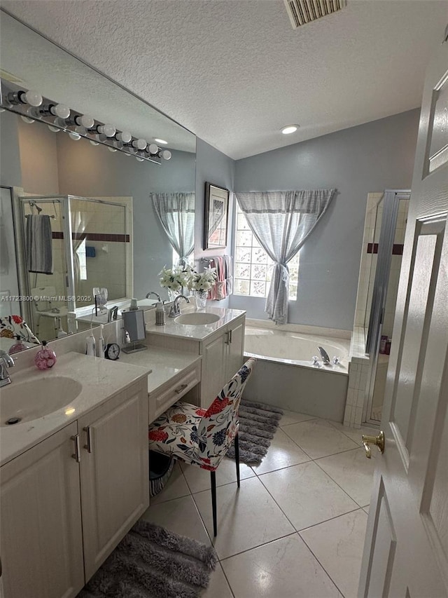 bathroom with tile patterned flooring, a textured ceiling, vanity, and shower with separate bathtub