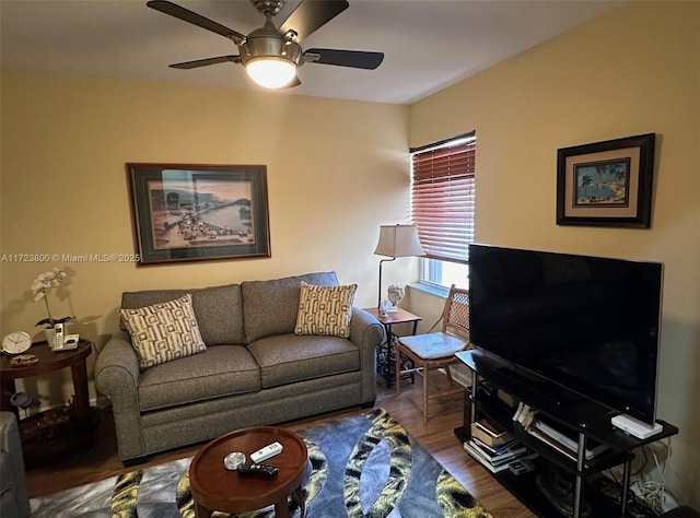 living room featuring dark wood-type flooring and ceiling fan