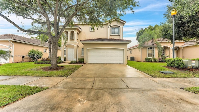 mediterranean / spanish home featuring a garage, cooling unit, and a front lawn