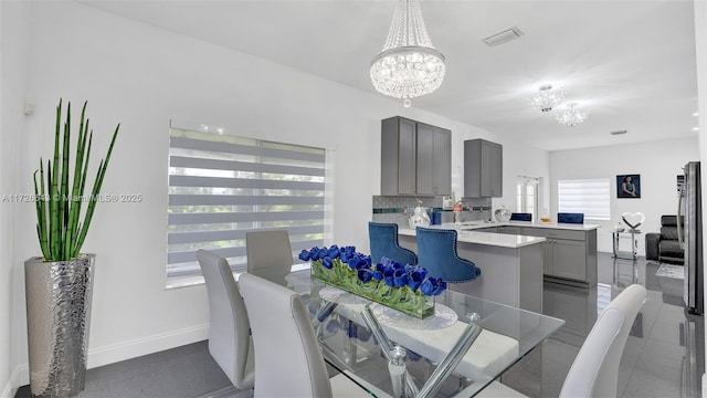 dining space featuring an inviting chandelier and dark tile patterned flooring