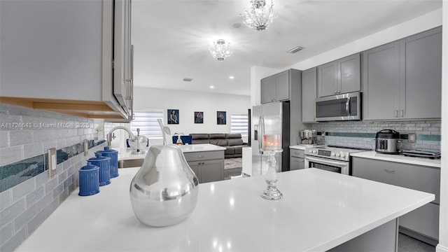 kitchen with backsplash, sink, gray cabinets, and stainless steel appliances