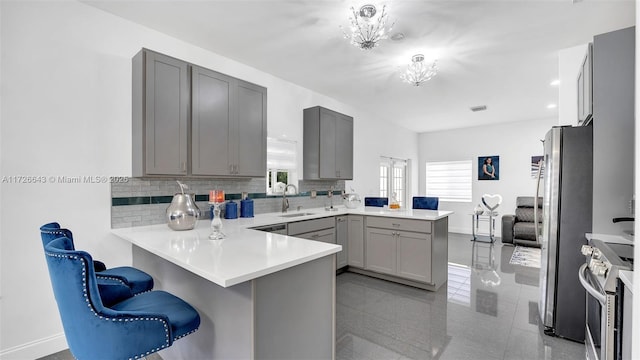 kitchen featuring a kitchen breakfast bar, sink, kitchen peninsula, and stainless steel appliances