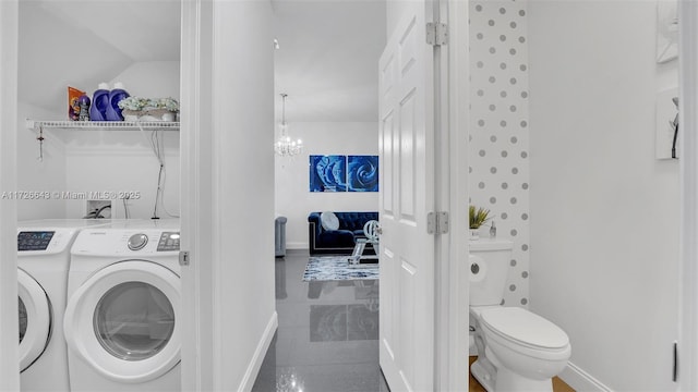 clothes washing area featuring washer and dryer and a chandelier