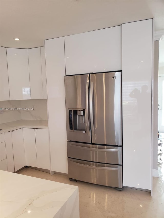 kitchen featuring stainless steel refrigerator with ice dispenser and white cabinetry