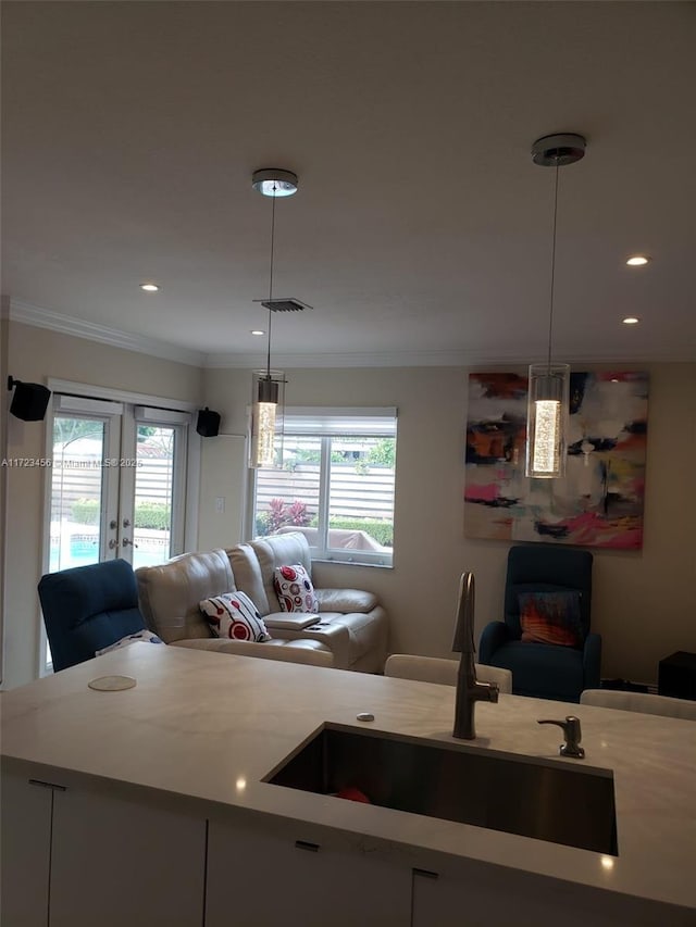 kitchen featuring white cabinetry, hanging light fixtures, and ornamental molding