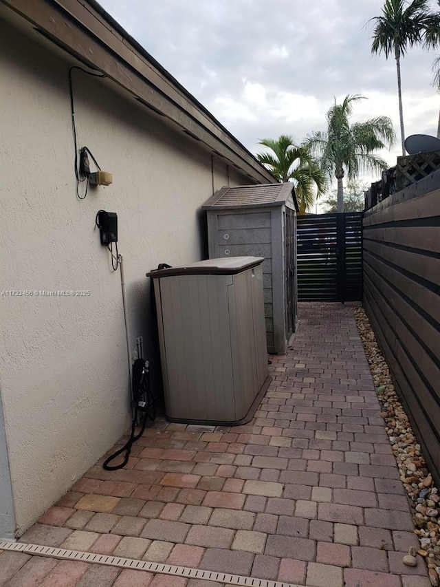 view of side of home with a storage shed