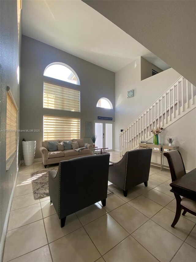 living room with light tile patterned floors and a high ceiling