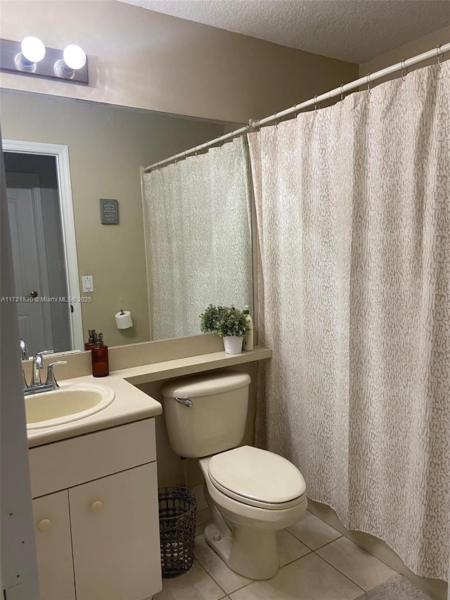 bathroom featuring tile patterned flooring, vanity, toilet, and a textured ceiling