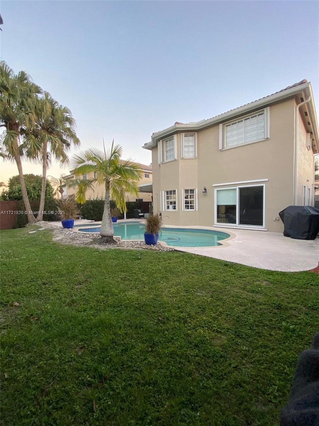 16445 SW 100th Ter, Miami, FL 33196 - back house at dusk featuring a lawn and a patio area