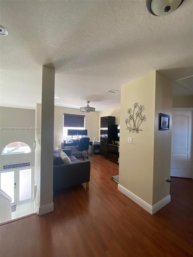 living room with dark hardwood / wood-style floors and a textured ceiling