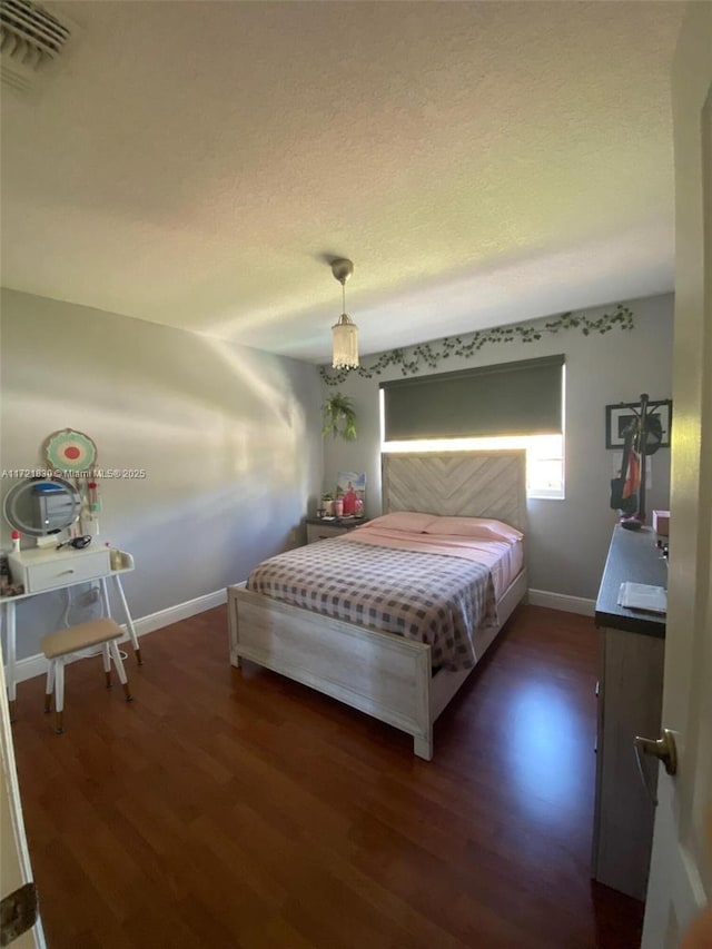 bedroom with dark hardwood / wood-style flooring and a textured ceiling