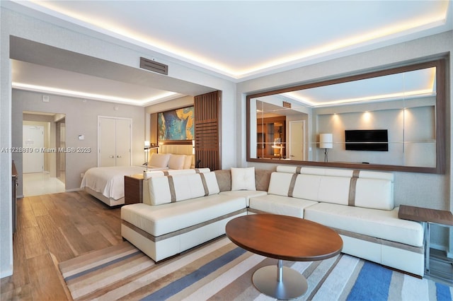 living room featuring a raised ceiling and hardwood / wood-style floors