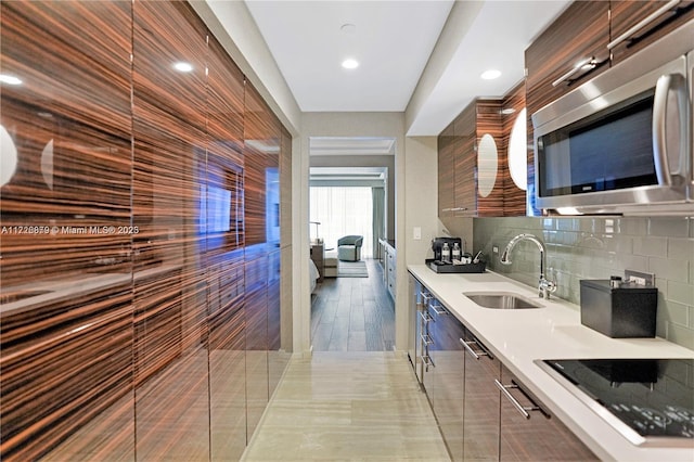 kitchen featuring tasteful backsplash, sink, and black electric cooktop