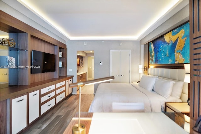 bedroom featuring dark wood-type flooring and ensuite bath