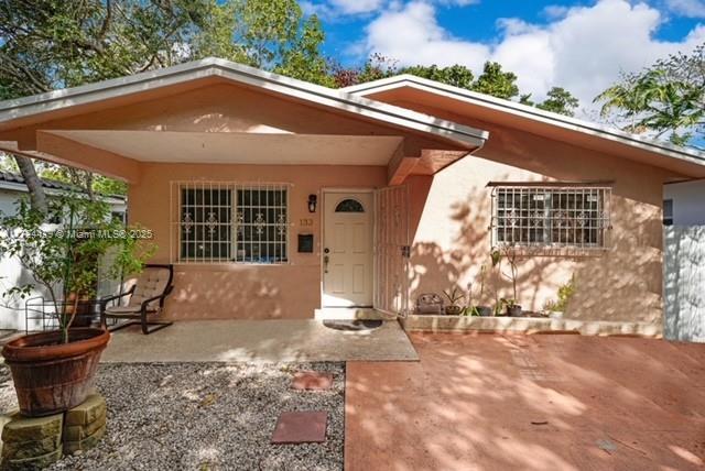 view of front of home with stucco siding and a patio
