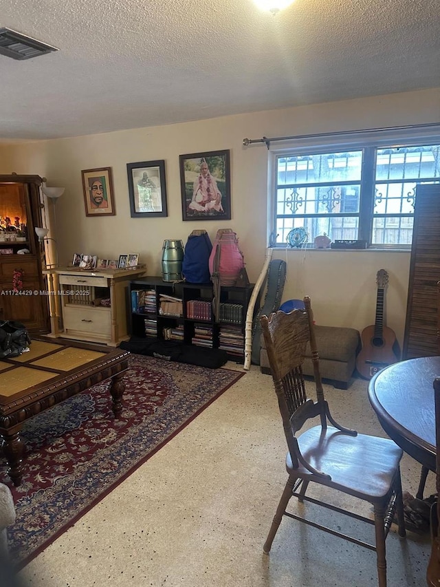 living room with visible vents and a textured ceiling