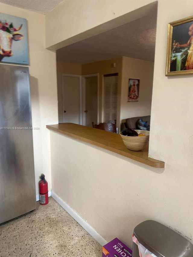 kitchen with freestanding refrigerator and baseboards