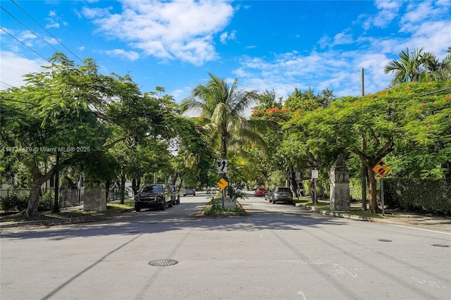 view of street featuring curbs, sidewalks, and traffic signs