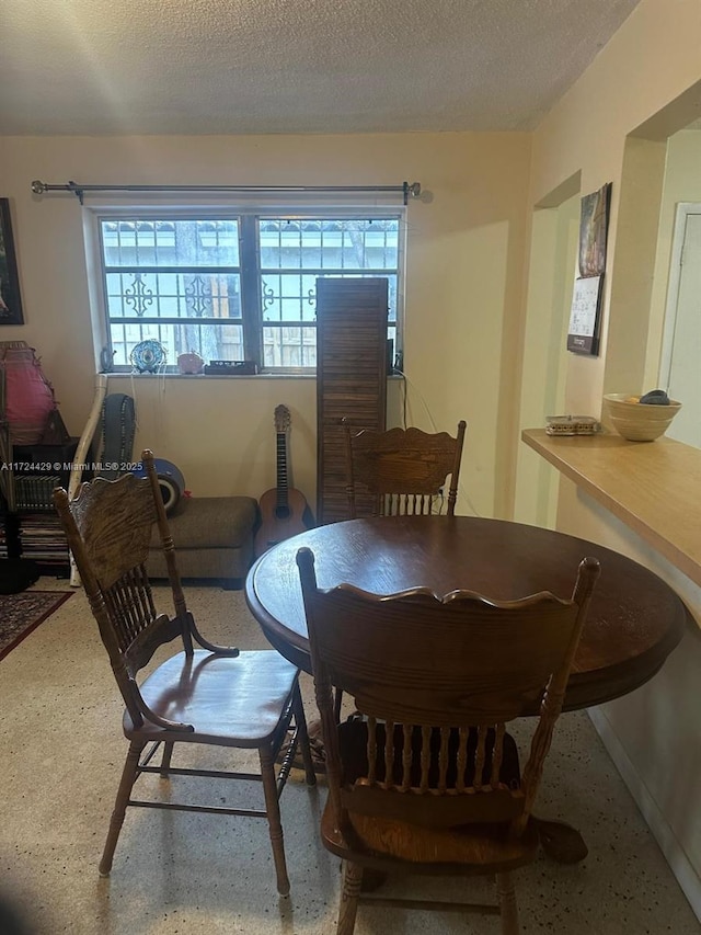 dining room featuring a textured ceiling and speckled floor