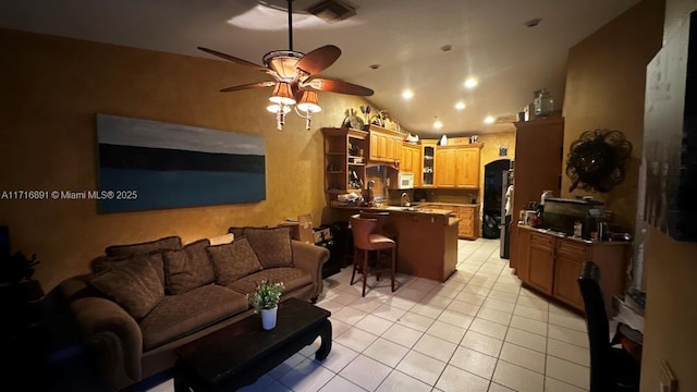 tiled living room featuring ceiling fan and vaulted ceiling