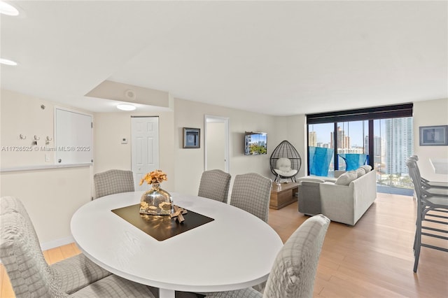 dining area featuring floor to ceiling windows and light hardwood / wood-style flooring