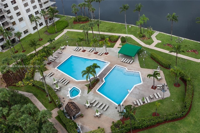 view of pool featuring a water view and a patio