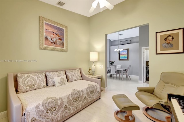 living room featuring ceiling fan with notable chandelier