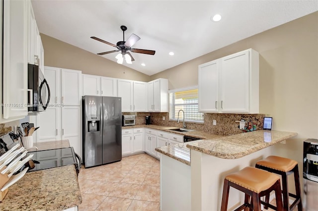 kitchen featuring sink, white cabinetry, a kitchen breakfast bar, stainless steel fridge with ice dispenser, and kitchen peninsula