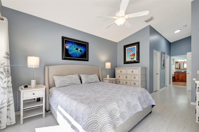 bedroom with connected bathroom, vaulted ceiling, light hardwood / wood-style floors, and ceiling fan