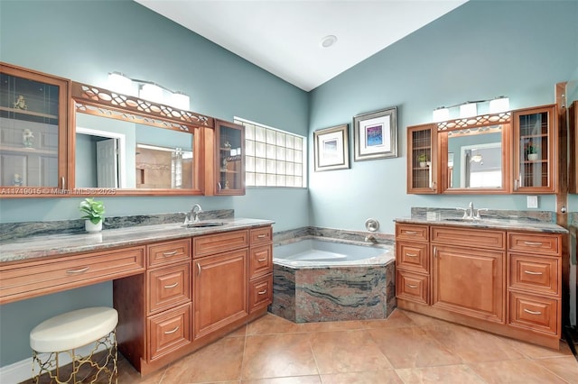 bathroom with vanity, tiled tub, and tile patterned flooring