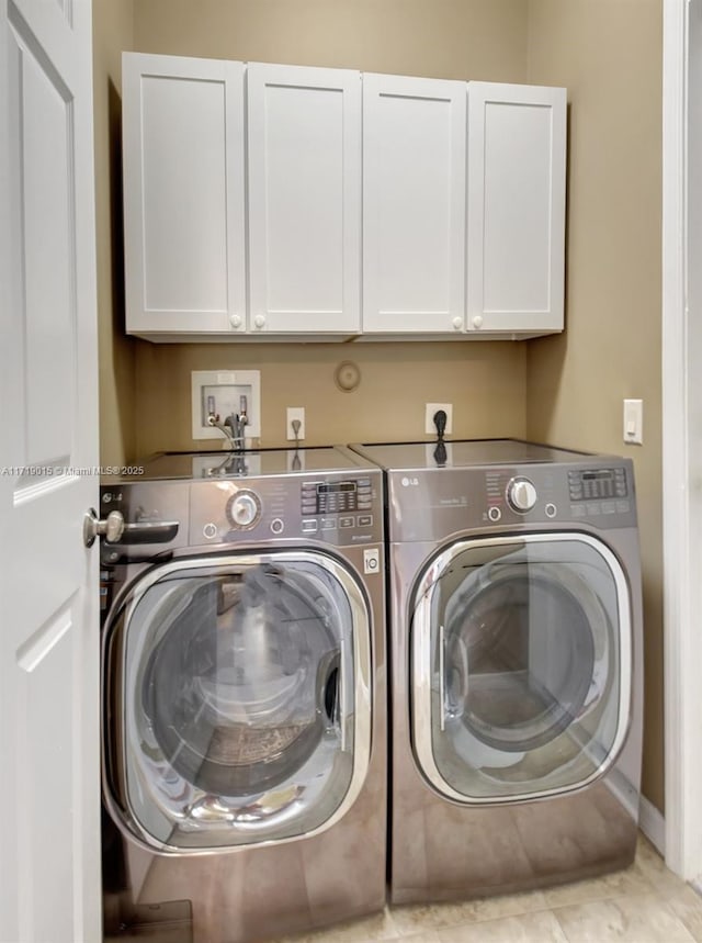 washroom featuring washer and clothes dryer and cabinets