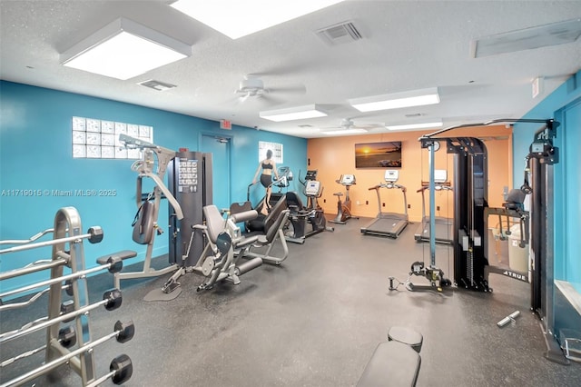 exercise room featuring ceiling fan and a textured ceiling