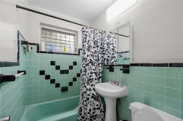 bathroom with tile walls, toilet, and shower / bathtub combination with curtain