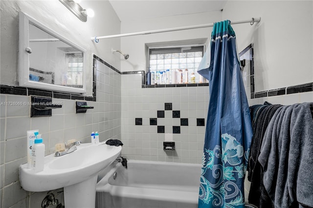 bathroom with tile walls and shower / bathtub combination with curtain